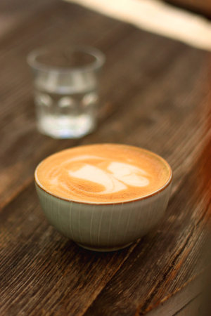 Coffee in a nice ceramic cup and glass of water on the table. Selective focus.の写真素材