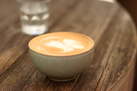Coffee in a nice ceramic cup and glass of water on the table. Selective focus.の写真素材