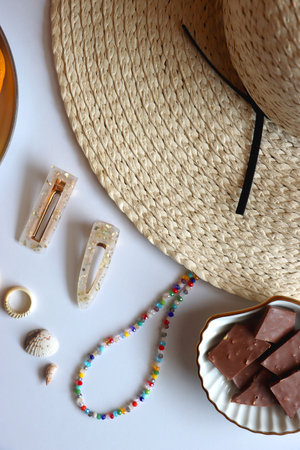 Straw hat, sunglasses, fresh fruit, chocolate and accessories. Summer essentials on the table. Top view.の写真素材