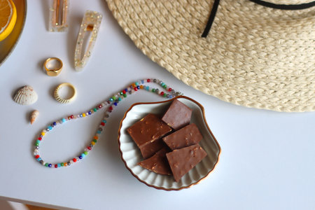 Glass of cocktail, straw hat, sunglasses, books, fresh fruit, chocolate and accessories. Summer essentials on the table. Selective focus.の写真素材