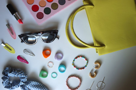 Green bag, various colorful jewelry, sunglasses, hair accessories and colorful make up on white background. Flat lay.の写真素材