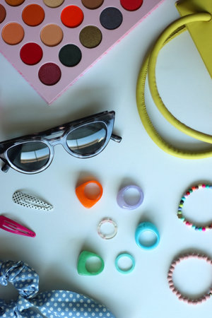 Green bag, various colorful jewelry, sunglasses, hair accessories and colorful make up on white background. Flat lay.の写真素材