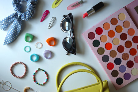Green bag, various colorful jewelry, sunglasses, hair accessories and colorful make up on white background. Flat lay.の写真素材