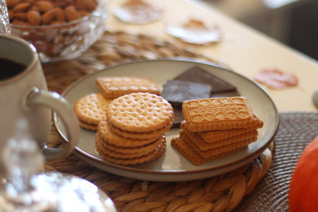 Cookies, chocolate, nuts, tea, wine, pumpkins, books, reading glasses and autumn leaves on the...