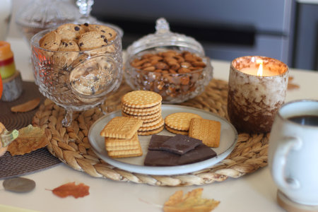 Lit candles, cookies, chocolate, nuts, tea, wine, pumpkins, books, reading glasses and autumn leaves...