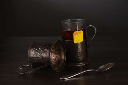 cup of tea and retro glass holders on the blackの写真素材