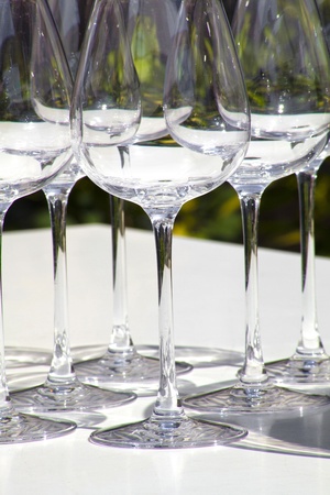 Six wine glasses on a sunny wine bar table の写真素材