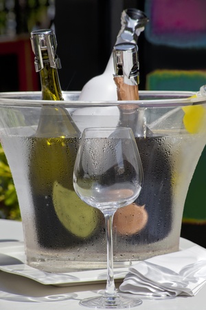 Served wine and one empty glass on a sunny bar tableの写真素材