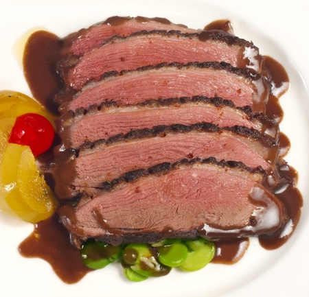 Baked pork slices in delicious gravy, served on a plateの写真素材