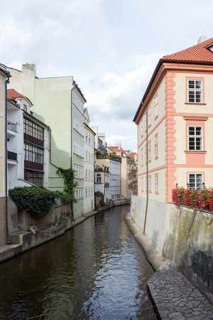 A row of charming colorful houses with flowery gardens, fencing the canal of Vltava river, in Prague, Czech Republicの写真素材