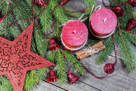 Winter background with fir branches, candles, cinnamon sticks and ornaments on wooden board. Christmas and New Year greeting card.の写真素材