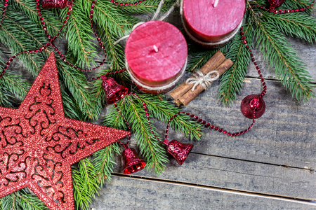 Winter background with fir branches, candles, cinnamon sticks and ornaments on wooden board. Christmas and New Year greeting card.の写真素材