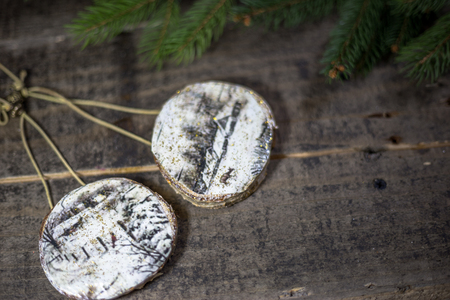 Handmade wooden ornaments with fir branches on the old floor. Concept of traditional Christmas celebration.の写真素材