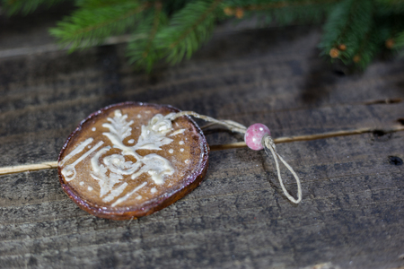 Handmade wooden ornament with fir branches on the old floor. Concept of traditional Christmas celebrationの写真素材