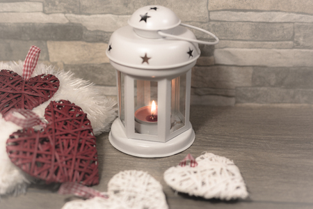 Winter composition with cozy pillow, lantern and heart ornaments. Winter holidays concept.の写真素材