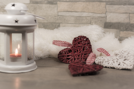 Winter composition with cozy pillow, lantern and heart ornaments. Winter holidays concept.の写真素材