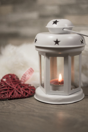 Winter composition with cozy pillow, lantern and heart ornament. Winter holidays concept.の写真素材