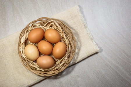 Chicken eggs in basket on light background. Top view with copy spaceの写真素材