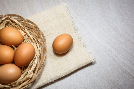 Chicken eggs in basket on light background. Top view with copy spaceの写真素材