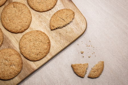 Fresh baked oat cookies on the wooden cutting board. Top view flat lay background.