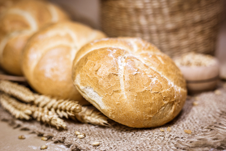 Close-up view of freshly baked bread on a rustic background with wheat and flour. Bakery and grocery concept.の写真素材