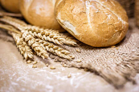 Close-up view of freshly baked bread on a rustic background with wheat and flour. Bakery and grocery concept.の写真素材