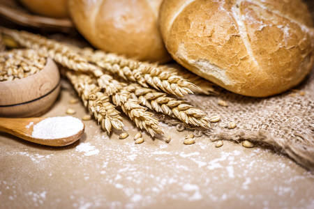 Close-up view of freshly baked bread on a rustic background with wheat and flour. Bakery and grocery concept.の写真素材