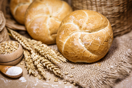 Close-up view of freshly baked bread on a rustic background with wheat and flour. Bakery and grocery concept.の写真素材