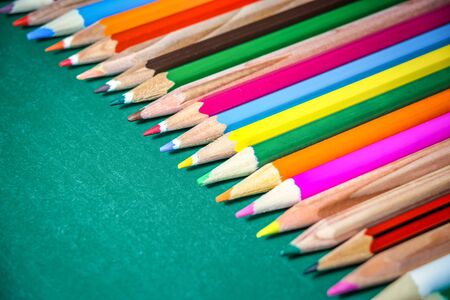 Colorful pencils on chalkboard background. Close-up photo with selective focus. Back to school concept.の写真素材