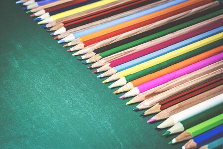 Colorful pencils on chalkboard background. Close-up photo with selective focus. Back to school...