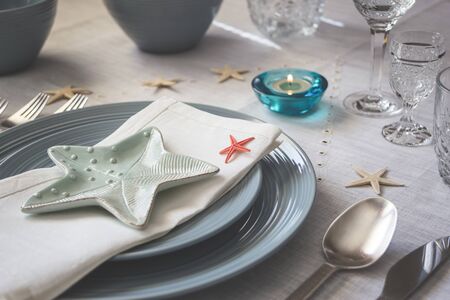 Summer table setting with napkin and starfish decoration. Close-up photo with selective focus.の写真素材