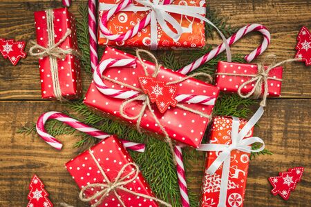 Christmas background with decorations and red gift boxes on wooden table. Top view with copy space.