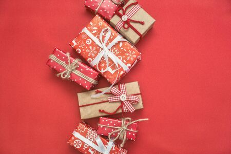 Christmas greeting card with different gift boxes on red background. Top view with copy space.