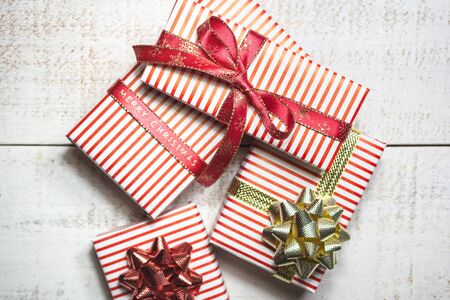 Christmas greeting card with different gift boxes on white wooden background. Top view with copy space.の写真素材