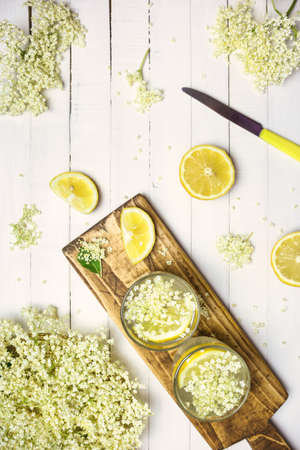 Two glasses of homemade elderflower lemonade and fresh ingredients for healthy and refreshing drink , top view.の写真素材