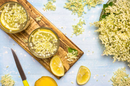 Two glasses of homemade elderflower lemonade and fresh ingredients for healthy and refreshing drink , top view.の写真素材