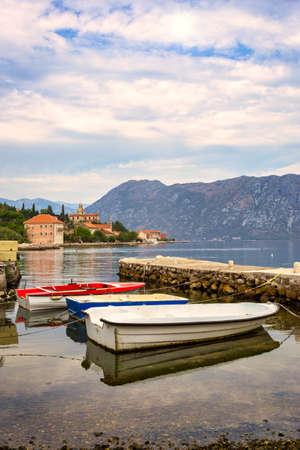 Fishing boats and traditional stone pier in the Bay of Kotor (Boka Kotorska), Montenegro, Europe. Travel concept, background.のeditorial素材