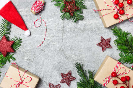 Christmas composition. Christmas gifts, ornaments, evergreen tree and ribbon on gray stone...