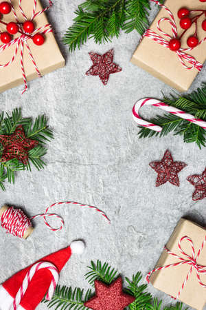 Christmas composition. Christmas gifts, ornaments, evergreen tree, candy cane and ribbon on gray stone background. Flat lay, top view, copy space.の写真素材