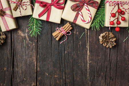 Christmas greeting card with different gift boxes on rustic wooden background. Top view with copy space. Winter holidays concept.の写真素材