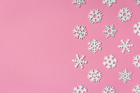 Christmas composition made of snowflakes on pastel pink background. Winter concept. Flat lay, top view, copy space.の写真素材