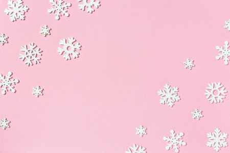 Christmas composition made of snowflakes on pastel pink background. Winter concept. Flat lay, top view, copy space.の写真素材