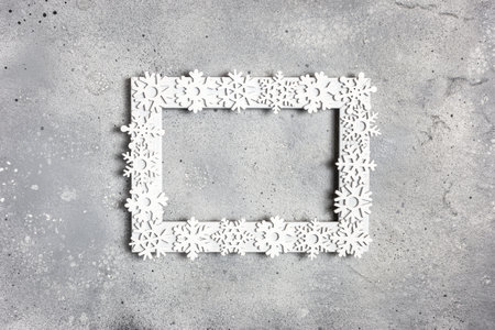 Christmas, winter composition. Xmas decorations, photo frame and snowflakes on gray stone background. Christmas, New Year, winter concept. Flat lay, top view, copy space.の写真素材