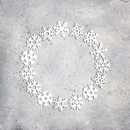 Christmas composition. Christmas frame made of snowflakes on gray stone background. Winter concept. Flat lay, top view, copy space.の写真素材