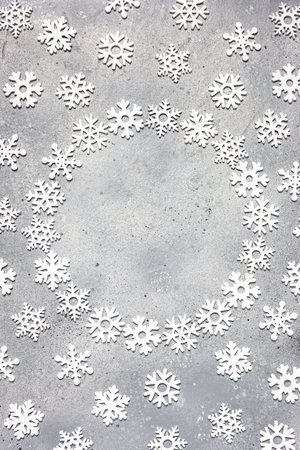 Christmas composition. Christmas frame made of snowflakes on gray stone background. Winter concept. Flat lay, top view, copy space.の写真素材