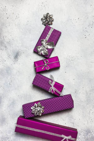 Christmas tree made of purple gifts boxes on gray stoneの写真素材