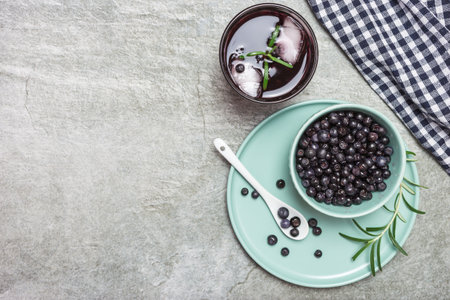 Organic blueberry in a bowl and fresh homemade blueberry juice on a gray stone table, top view with space for text. Healthy eating and nutrition concept.の写真素材