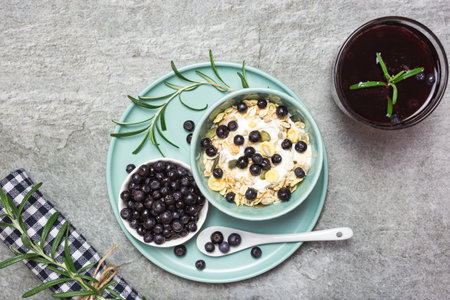 Greek yogurt, granola with blueberries and fresh juice on a stone table, top view with space for text. Healthy food, snack or breakfast.の写真素材
