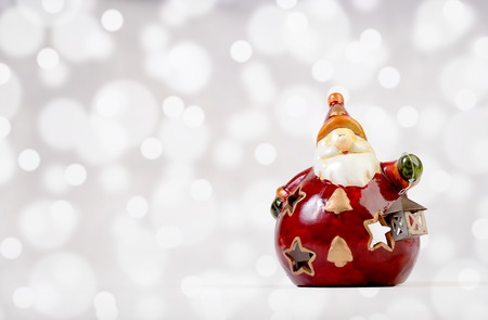 Ceramic cute Santa Claus decoration on bokeh backgroundの写真素材