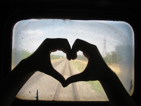 Silhouette Of Hands Making Heart On A Background Of A Dirty Train Windowの写真素材